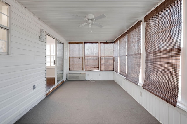 unfurnished sunroom featuring a ceiling fan and a wall mounted air conditioner