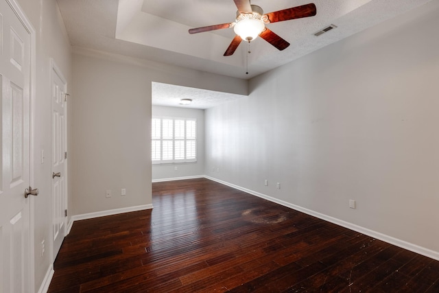 spare room with visible vents, ceiling fan, a textured ceiling, baseboards, and hardwood / wood-style flooring