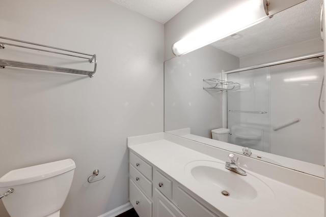 bathroom with a shower with door, vanity, toilet, and a textured ceiling