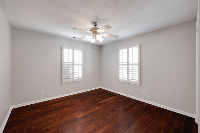 spare room with visible vents, baseboards, ceiling fan, dark wood-type flooring, and a textured ceiling