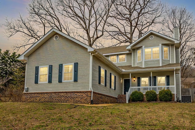 view of front of property featuring covered porch, a chimney, cooling unit, and a front yard