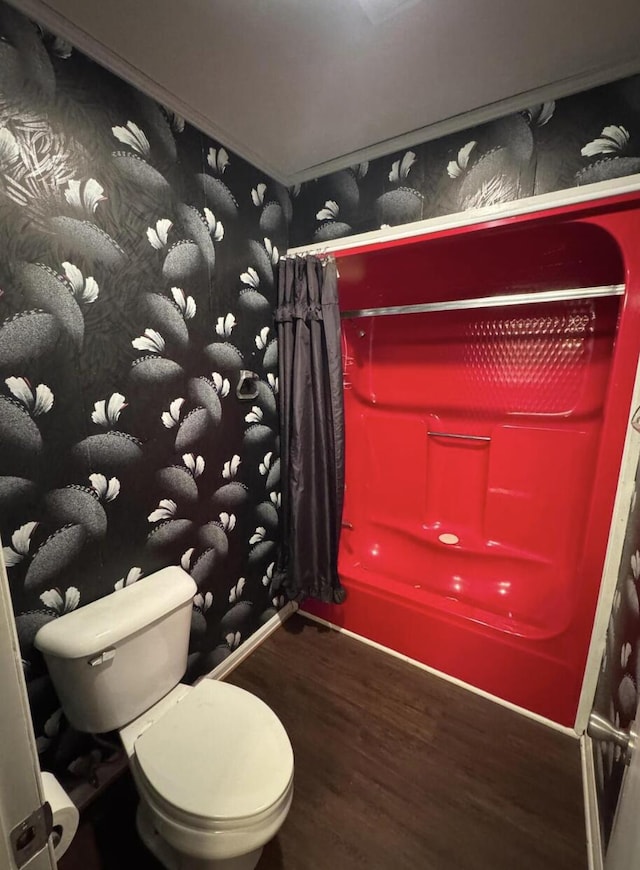 bathroom featuring hardwood / wood-style flooring, toilet, and shower / bath combo with shower curtain