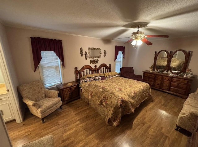 bedroom with wood-type flooring, crown molding, ceiling fan, and a textured ceiling