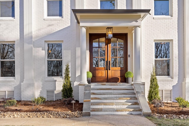 doorway to property featuring french doors and brick siding