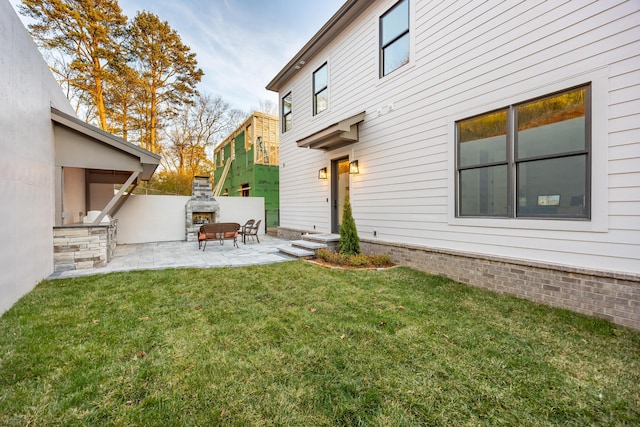 view of yard featuring an outdoor fireplace and a patio