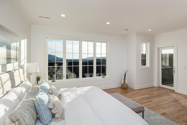 bedroom with baseboards, recessed lighting, wood finished floors, and crown molding