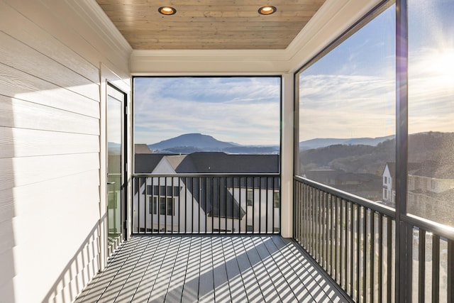 sunroom with wooden ceiling, a mountain view, and a wealth of natural light