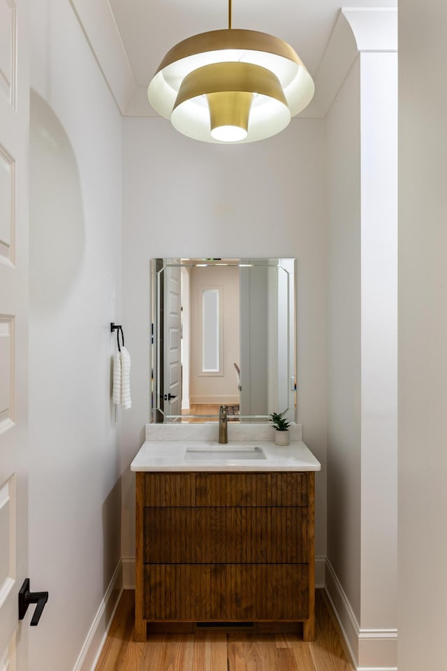 bathroom featuring wood finished floors, vanity, and baseboards