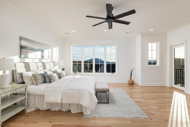 bedroom featuring light wood-style floors, multiple windows, and crown molding