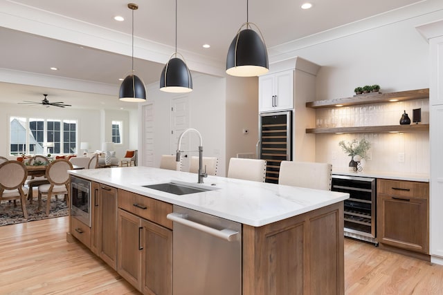 kitchen with wine cooler, a sink, hanging light fixtures, appliances with stainless steel finishes, and open shelves