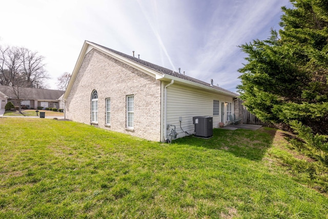 view of side of property featuring central AC and a lawn