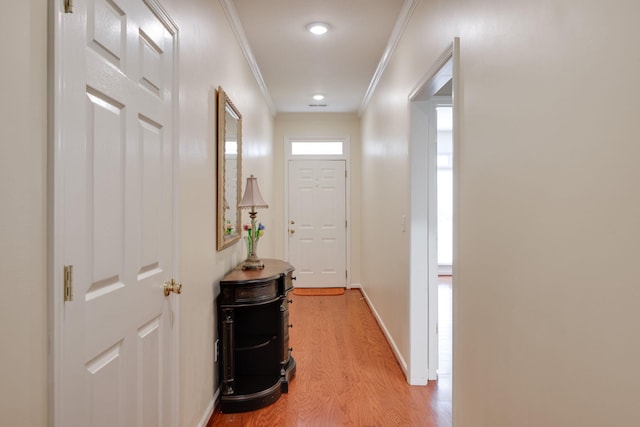 hall featuring light wood-type flooring and crown molding