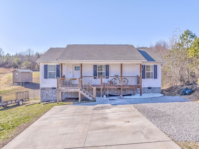 view of front of home with a porch and a storage unit