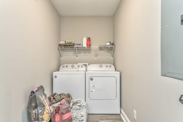 laundry area featuring hardwood / wood-style flooring, electric panel, and washer and dryer