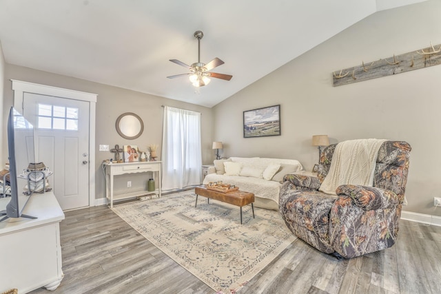 living room with hardwood / wood-style flooring, lofted ceiling, and a wealth of natural light