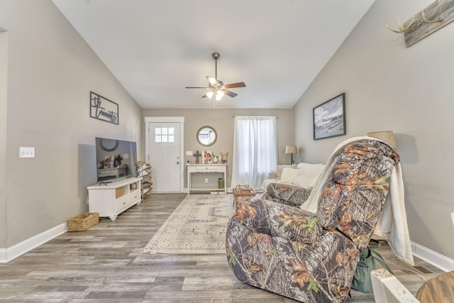 living room with ceiling fan, lofted ceiling, and light wood-type flooring