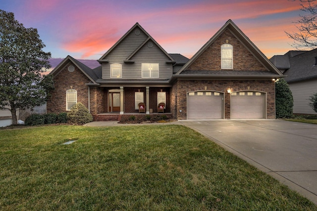 view of front of house featuring a yard, covered porch, and a garage