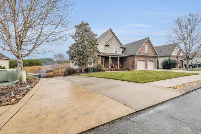 view of front of house featuring a garage, a front yard, and covered porch