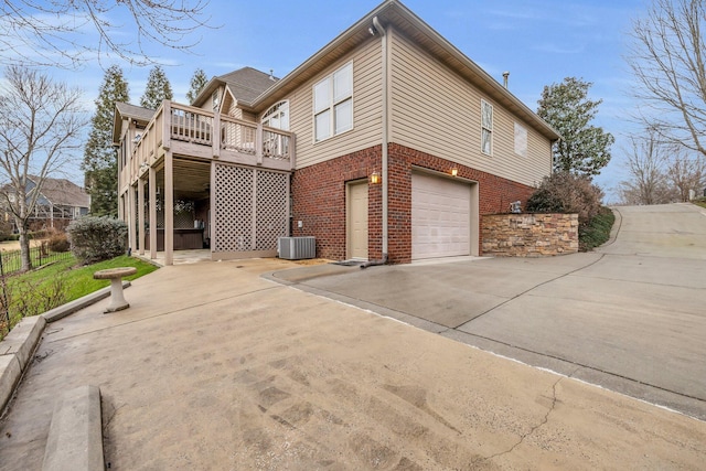 view of side of home with a garage, central AC, and a deck