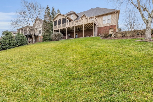 rear view of property featuring a wooden deck, a lawn, and a sunroom