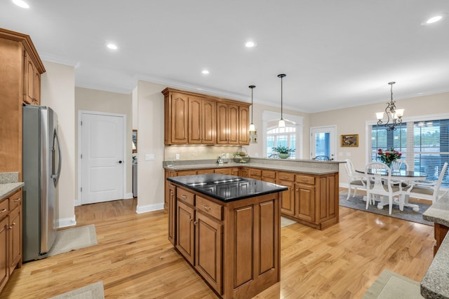 kitchen featuring stainless steel refrigerator with ice dispenser, light hardwood / wood-style flooring, and decorative light fixtures