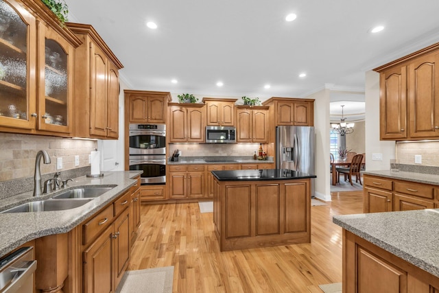 kitchen with sink, light hardwood / wood-style flooring, appliances with stainless steel finishes, tasteful backsplash, and ornamental molding