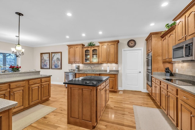 kitchen featuring sink, a center island, hanging light fixtures, dark stone countertops, and stainless steel appliances