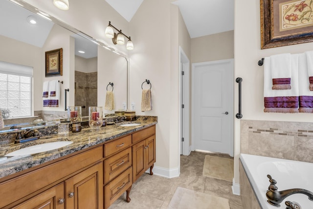 bathroom featuring vanity, vaulted ceiling, and a tub