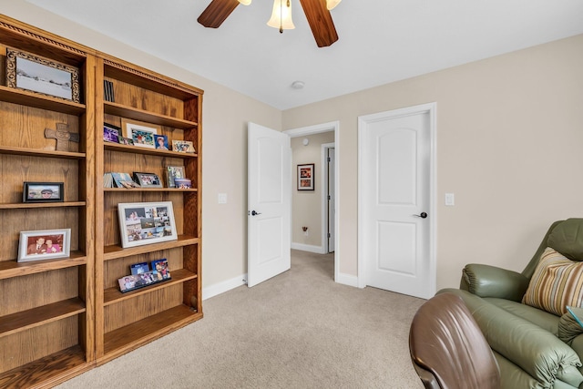 living area featuring light colored carpet and ceiling fan