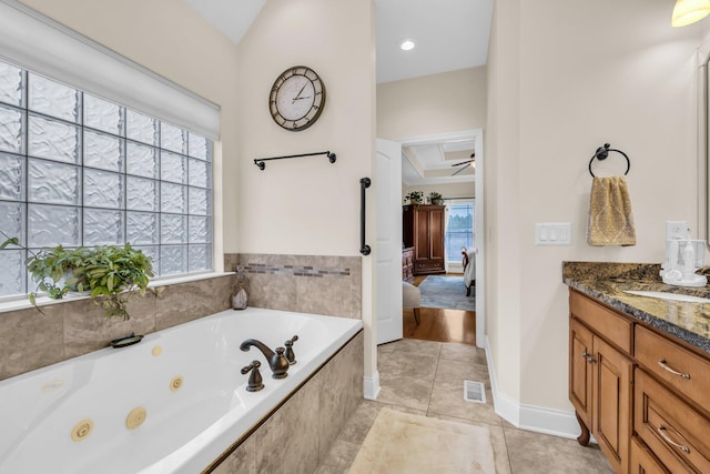 bathroom featuring vanity, tiled bath, and ceiling fan