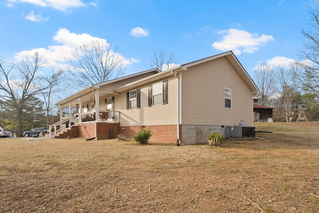 view of property exterior featuring a porch, central air condition unit, and a lawn