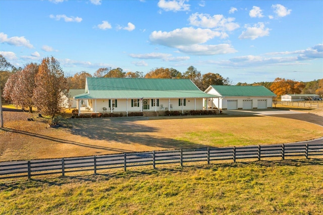 farmhouse inspired home with a garage, dirt driveway, a fenced front yard, covered porch, and a front yard