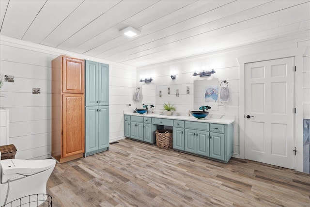 full bathroom featuring double vanity, toilet, wooden ceiling, wood finished floors, and a sink