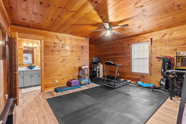 workout room with wood walls, wooden ceiling, and light wood-style floors