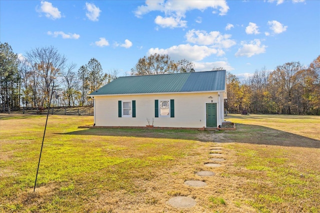 view of front of house with fence, metal roof, and a front yard