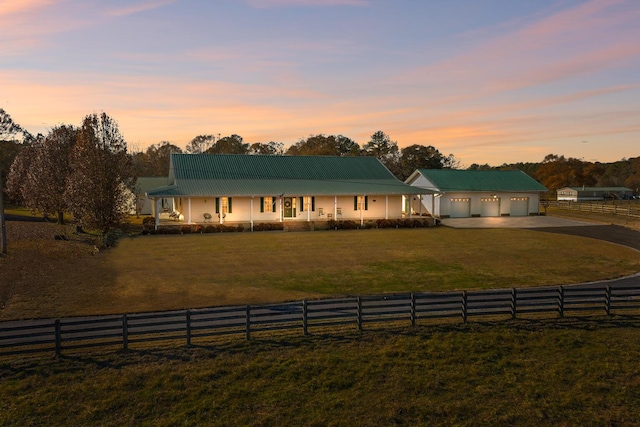 farmhouse with a yard, a garage, an outdoor structure, and covered porch