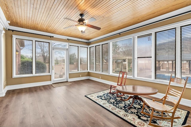 unfurnished sunroom featuring plenty of natural light, wood ceiling, and ceiling fan