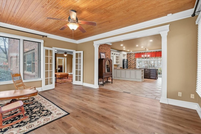 unfurnished living room with french doors, light wood-type flooring, wooden ceiling, ornamental molding, and decorative columns