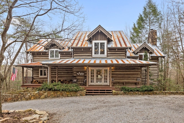 log home featuring covered porch and french doors