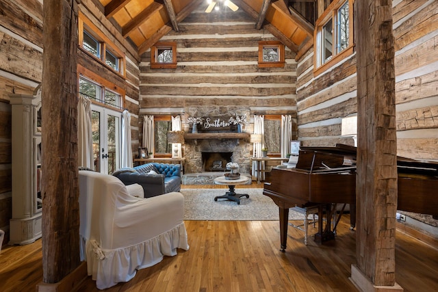 living room with a fireplace, french doors, wood ceiling, vaulted ceiling with beams, and hardwood / wood-style floors