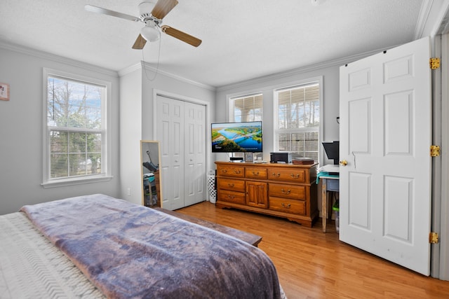 bedroom with a ceiling fan, a textured ceiling, wood finished floors, and crown molding