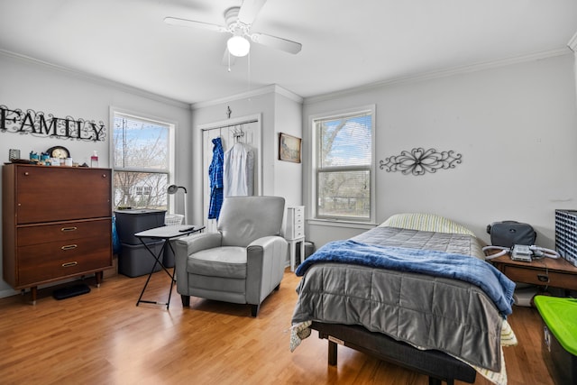 bedroom featuring a closet, light wood finished floors, and ornamental molding