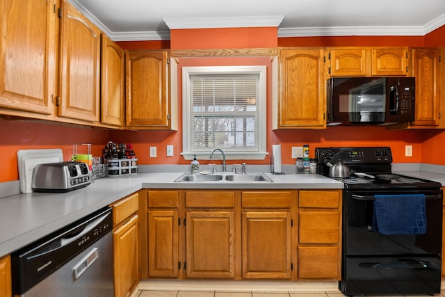 kitchen featuring black appliances, crown molding, light countertops, and a sink