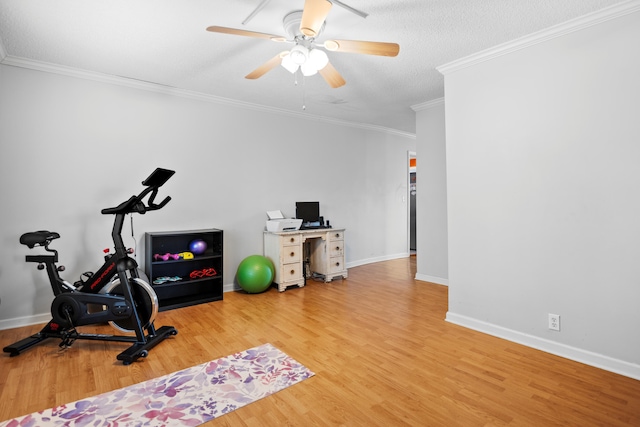 exercise room featuring baseboards, wood finished floors, a ceiling fan, and ornamental molding