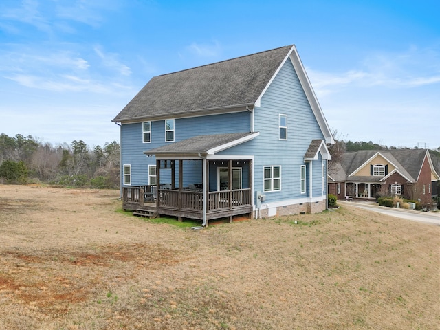rear view of property featuring a yard and a deck