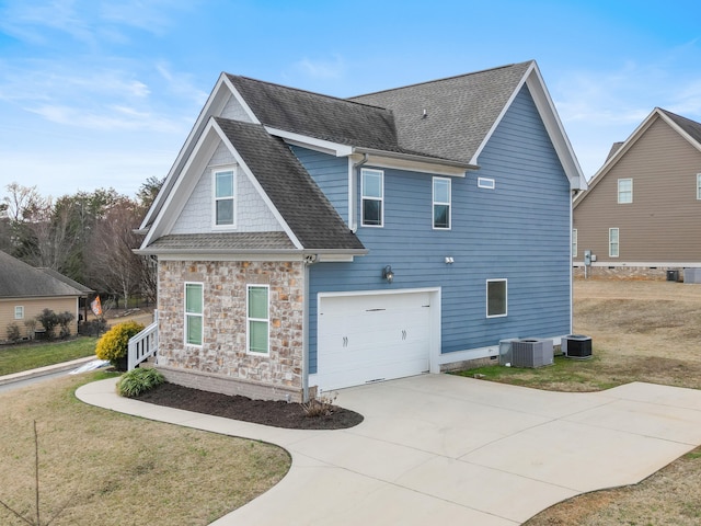 view of home's exterior featuring cooling unit, a garage, and a yard