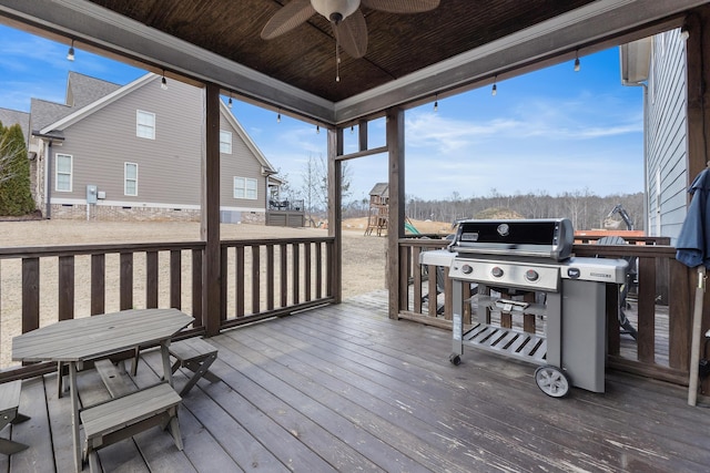 deck featuring ceiling fan, grilling area, and a playground