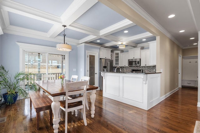 kitchen featuring decorative light fixtures, beamed ceiling, white cabinets, backsplash, and stainless steel appliances