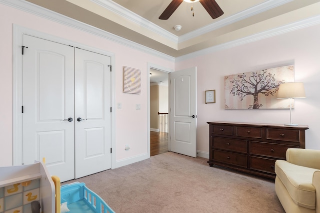sitting room featuring ceiling fan, light colored carpet, ornamental molding, and a raised ceiling