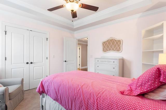 carpeted bedroom featuring ornamental molding, ceiling fan, and a closet